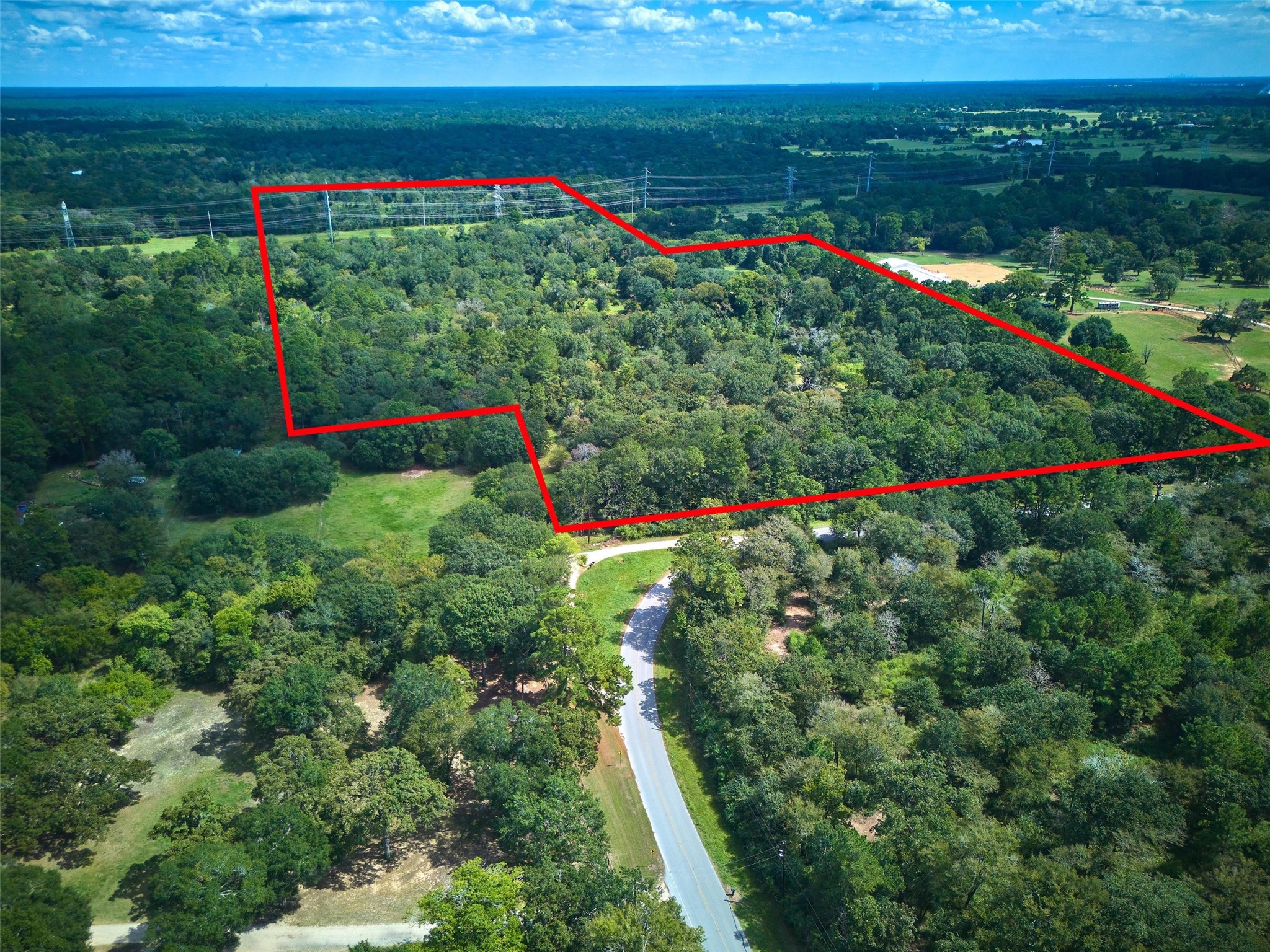 24030 Hegar Road Hockley, TX 77447 - Photo 3 of 40 This aerial view showcases the full 50-acre tract outlined in red, highlighting the impressive size and layout of the property. With open pastures, clusters of mature oak trees, and a scenic pond, the land offers endless opportunities for ranching, recreation, or building your dream estate. The clear boundary lines give a true perspective of the acreage and privacy this unique Hockley property provides.