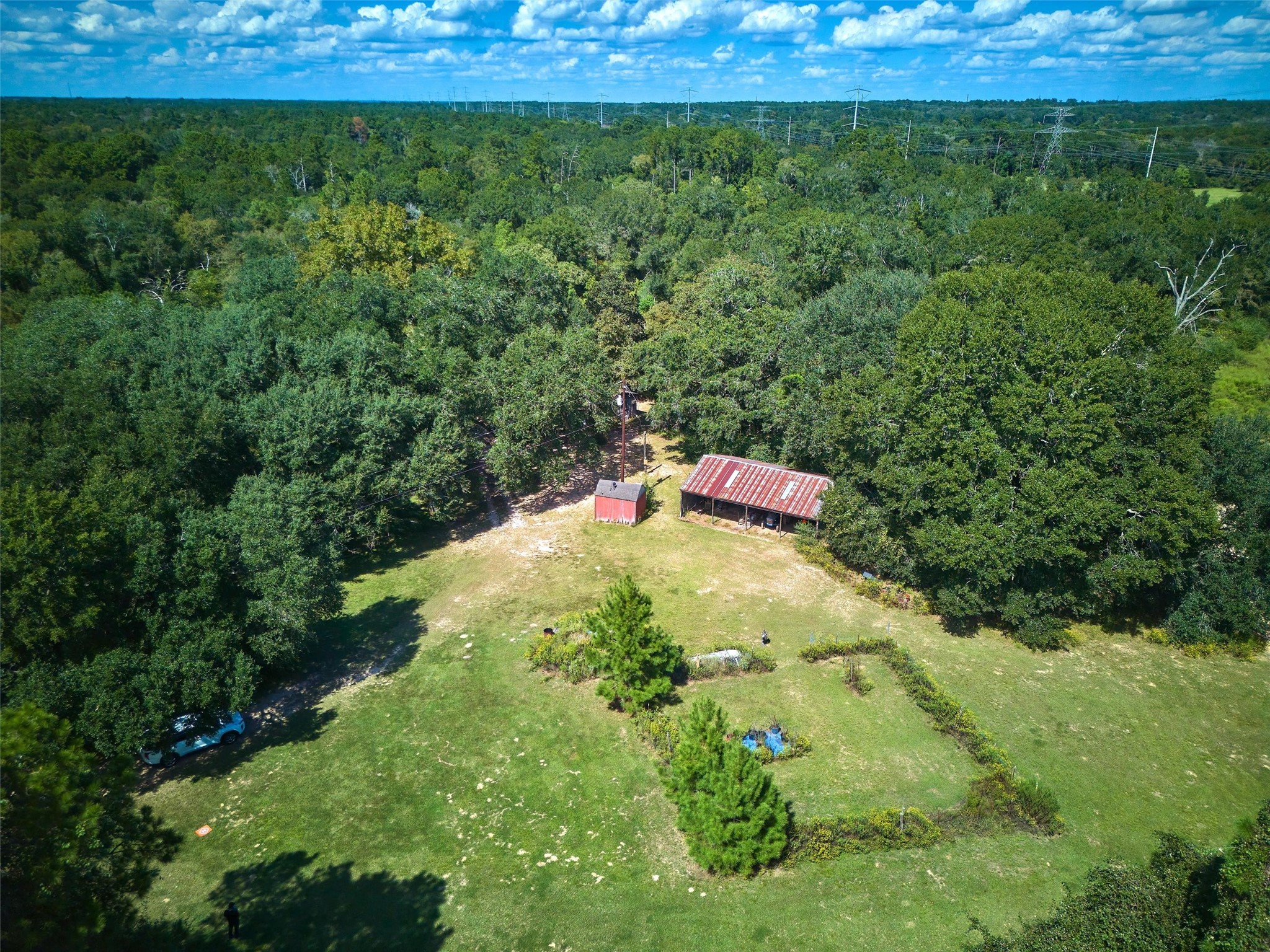 24030 Hegar Road Hockley, TX 77447 - Photo 4 of 40 This aerial view captures the property’s expansive layout and highlights the charming garden below. Surrounded by mature trees and open green space, the garden adds both beauty and function—perfect for growing vegetables, flowers, or creating a peaceful outdoor retreat.