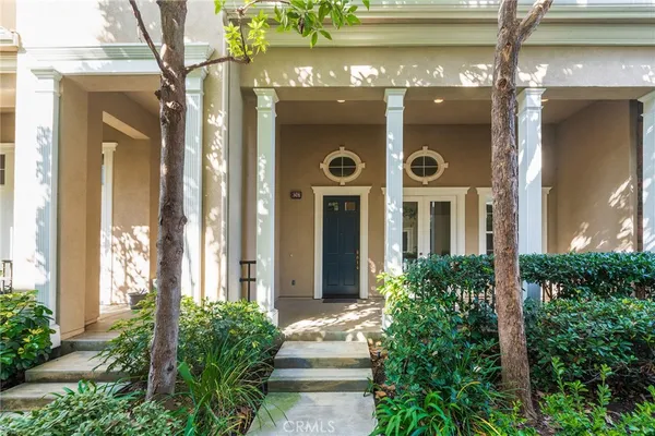 a view of a door of the house with potted plants