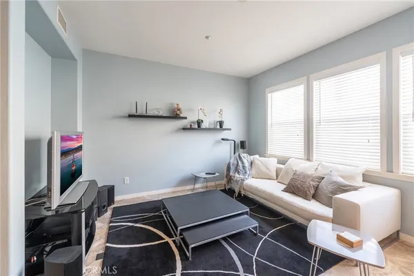 a kitchen with stainless steel appliances granite countertop a stove a sink a microwave a refrigerator and white cabinets