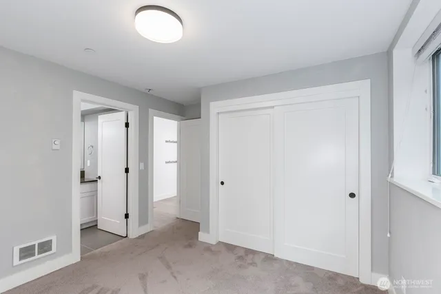 a bathroom with a granite countertop sink a toilet and mirror