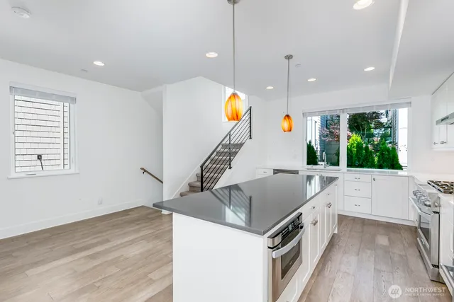 a kitchen with stainless steel appliances granite countertop a sink a oven and a large window