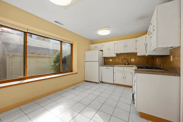 a kitchen with a refrigerator a stove top oven and a cabinets