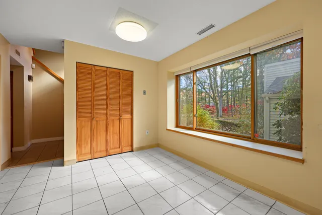 a view of an empty room with window chandelier