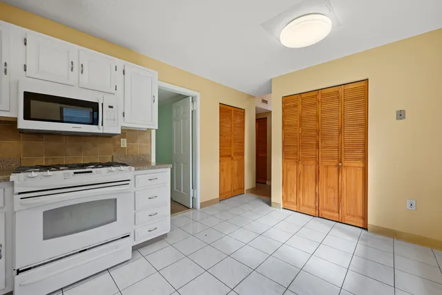 a kitchen with granite countertop cabinets stainless steel appliances and a window