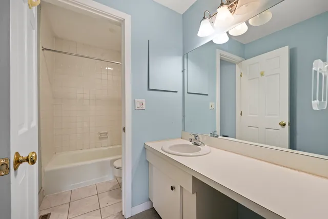 a bathroom with a granite countertop sink a mirror and a bathtub