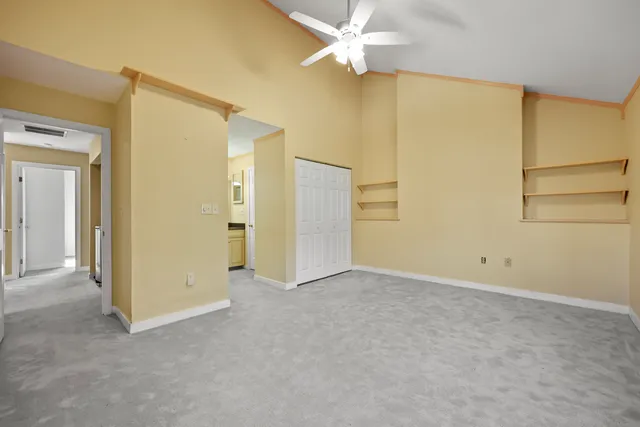 an empty room with a ceiling fan and a window