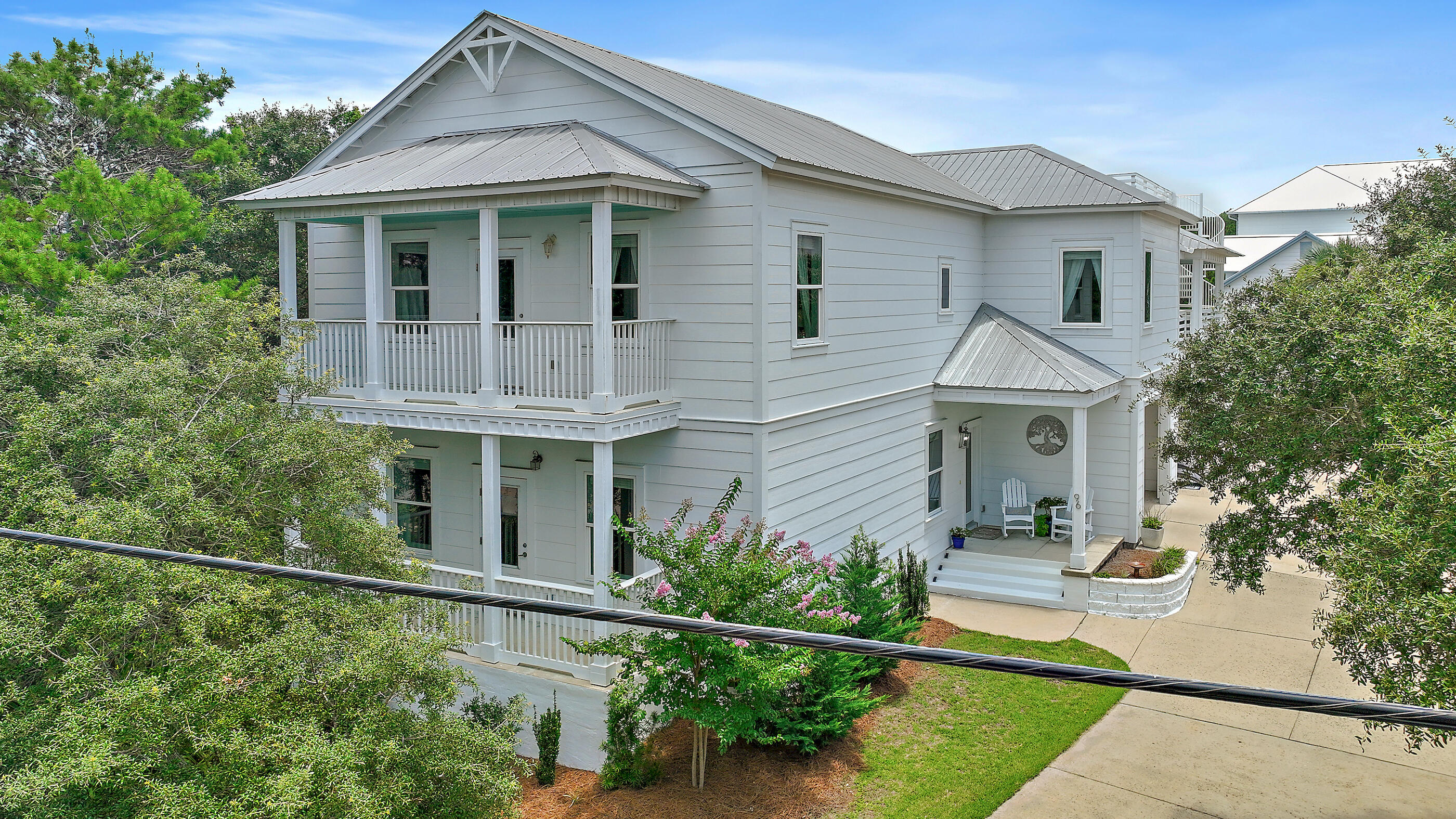 96 Hilltop Drive Santa Rosa Beach, FL 32459 - Photo 2 of 50 a view of a white house next to a yard with potted plants