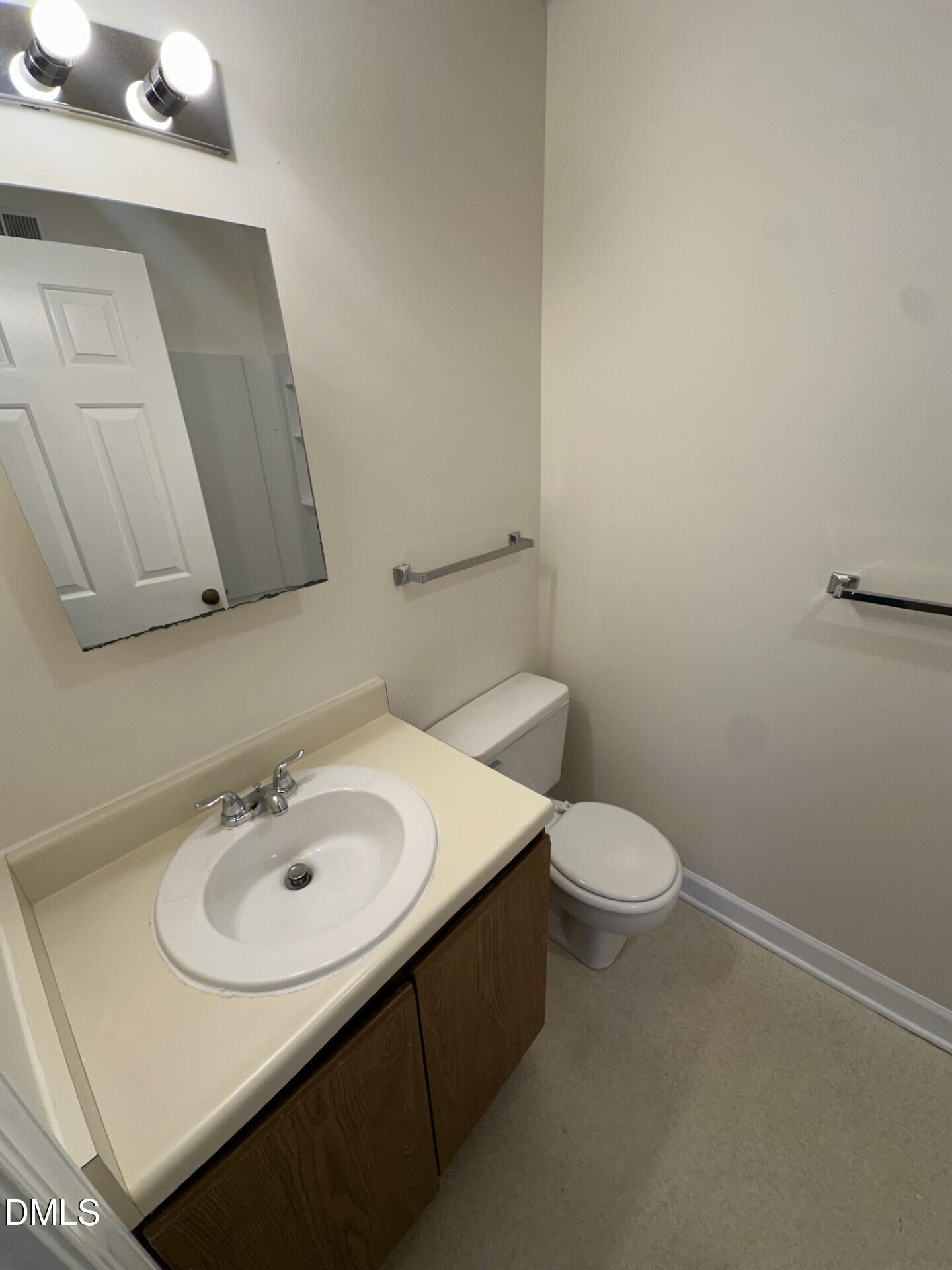 3515 Ivy Commons Drive, Unit 301 Raleigh, NC 27606 - Photo 6 of 6 a bathroom with a sink a toilet and mirror
