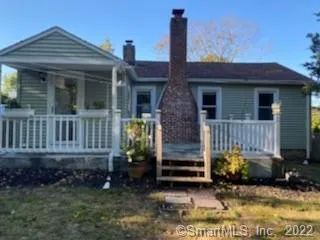 a view of a house with a yard and potted plants