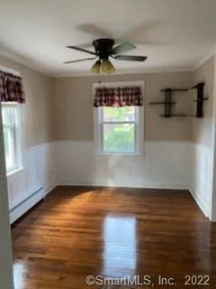 a view of an empty room with window and wooden floor