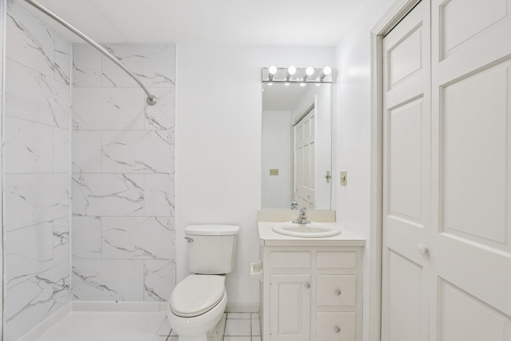 11 Thaxton Road Beverly, MA 01915 - Photo 30 of 40 a bathroom with a granite countertop sink a toilet and a mirror