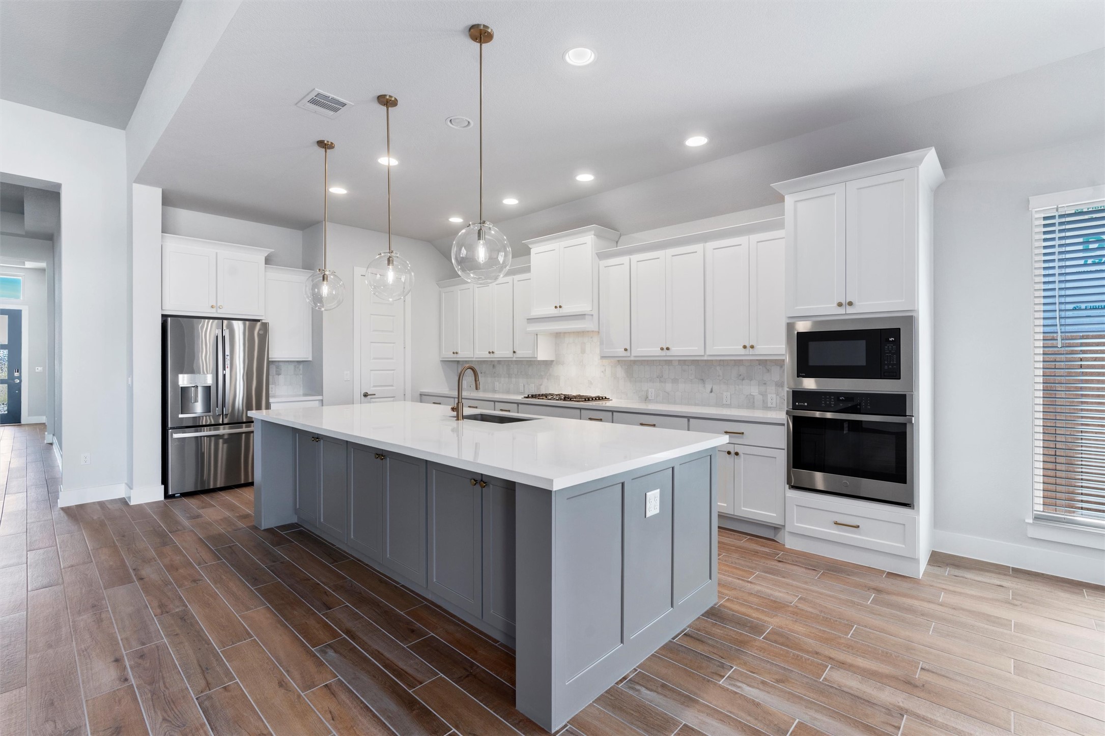 8516 Picnic House Path Austin, TX 78744 - Photo 5 of 39 a large kitchen with stainless steel appliances a stove a sink and a refrigerator