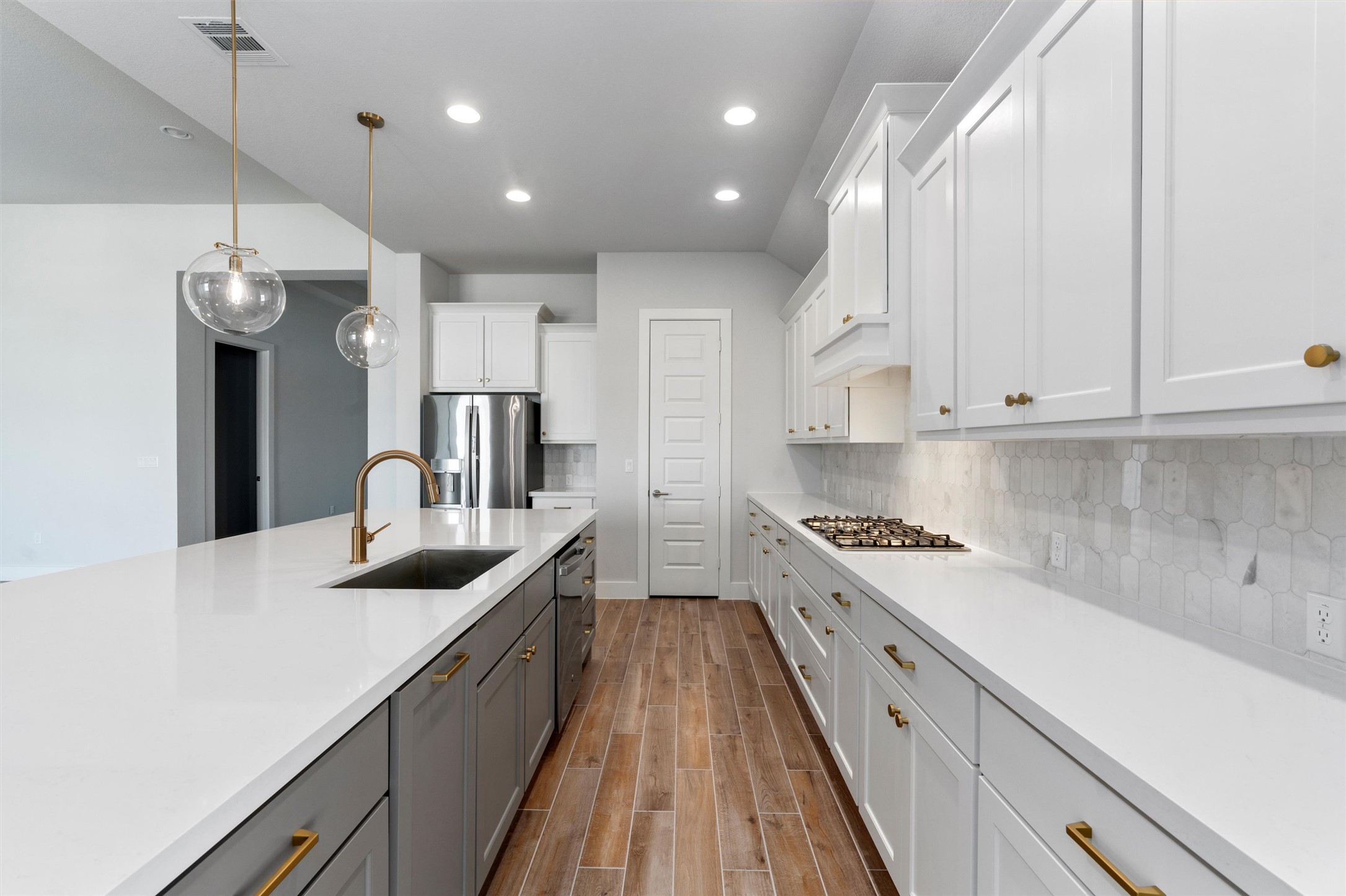 8516 Picnic House Path Austin, TX 78744 - Photo 6 of 39 a large kitchen with stainless steel appliances granite countertop a lot of counter space and wooden floors