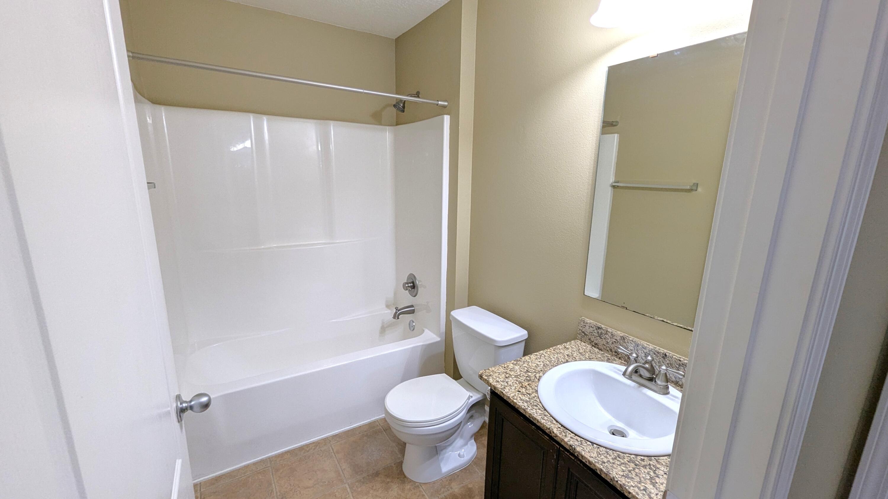 7976 Promise Creek Road Navarre, FL 32566 - Photo 13 of 29 a bathroom with a granite countertop sink toilet and shower