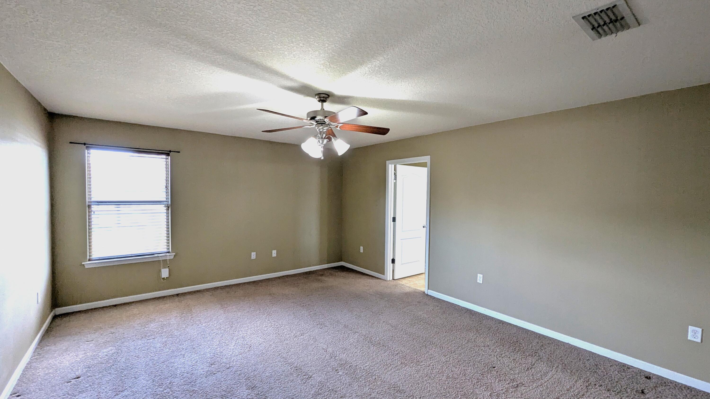 7976 Promise Creek Road Navarre, FL 32566 - Photo 20 of 29 an empty room with windows and chandelier fan