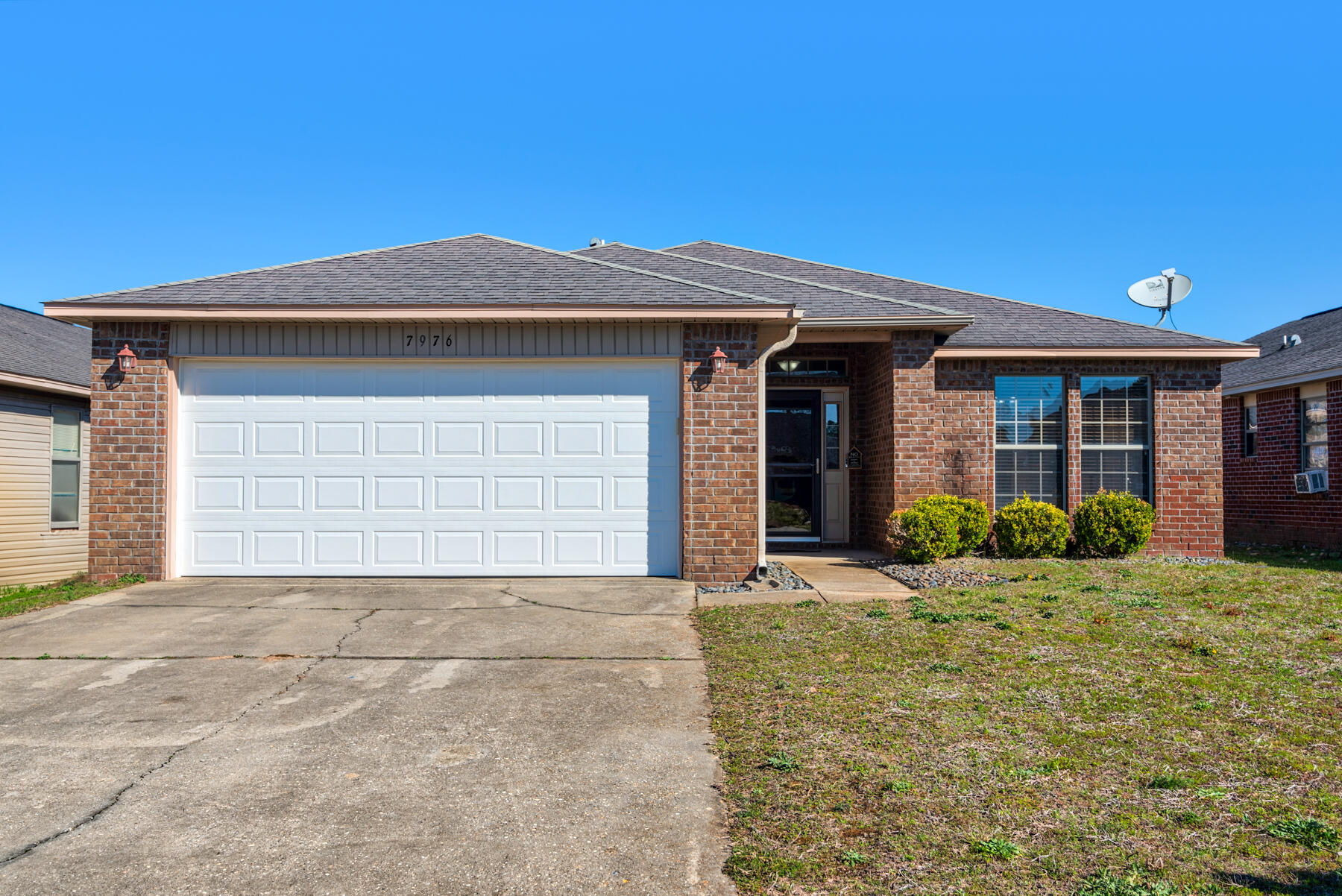 7976 Promise Creek Road Navarre, FL 32566 - Photo 2 of 29 a front view of a house with a yard and garage