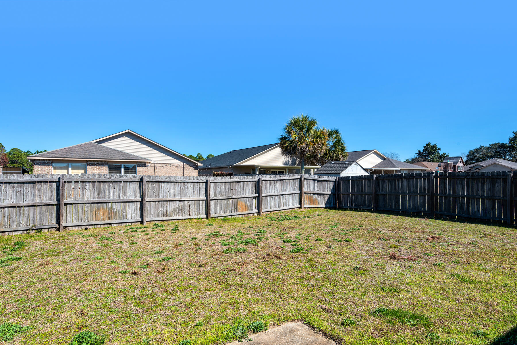 7976 Promise Creek Road Navarre, FL 32566 - Photo 26 of 29 a white house with a yard and wooden fence