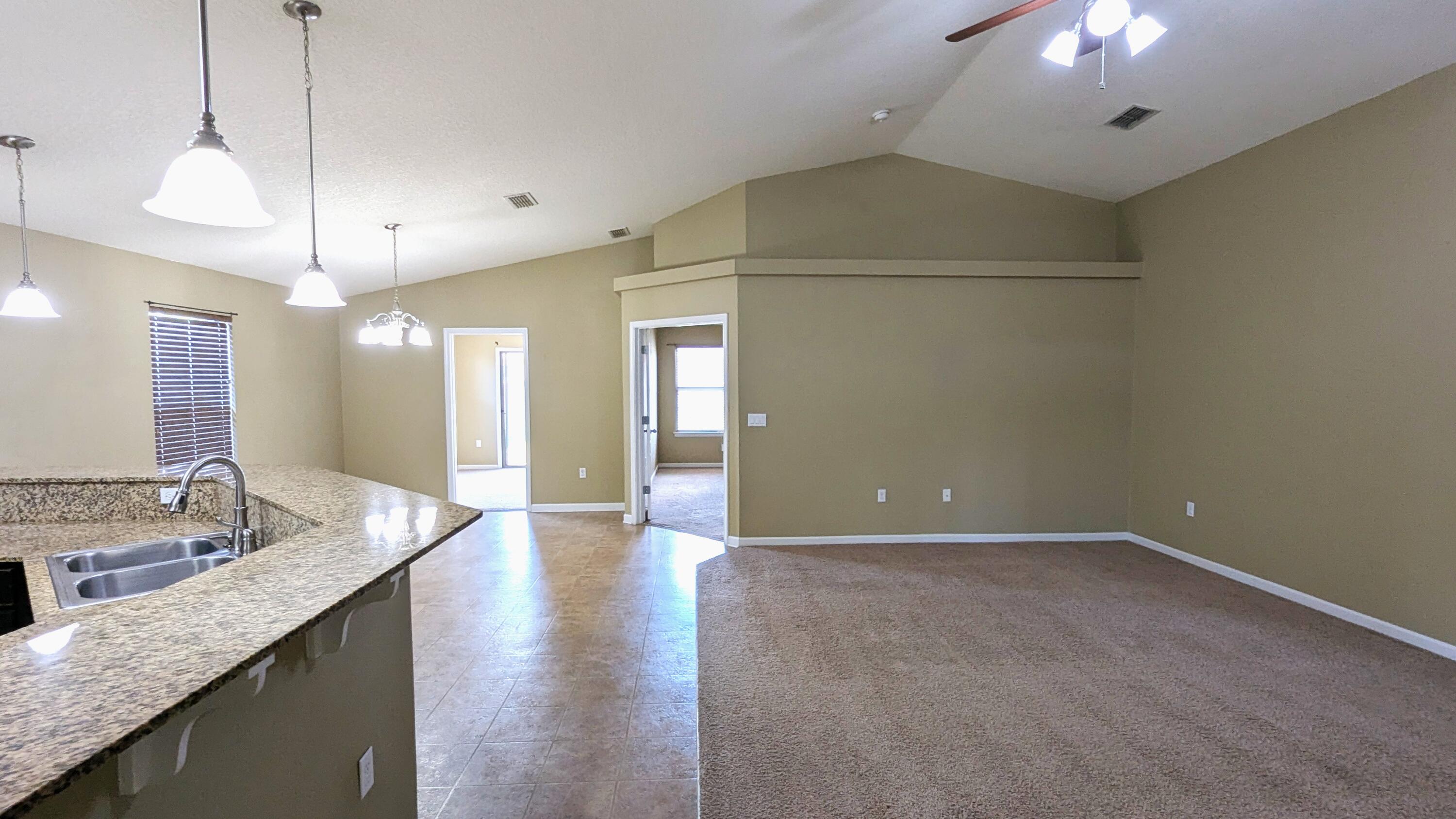 7976 Promise Creek Road Navarre, FL 32566 - Photo 9 of 29 a view of a kitchen island a sink and a chandelier