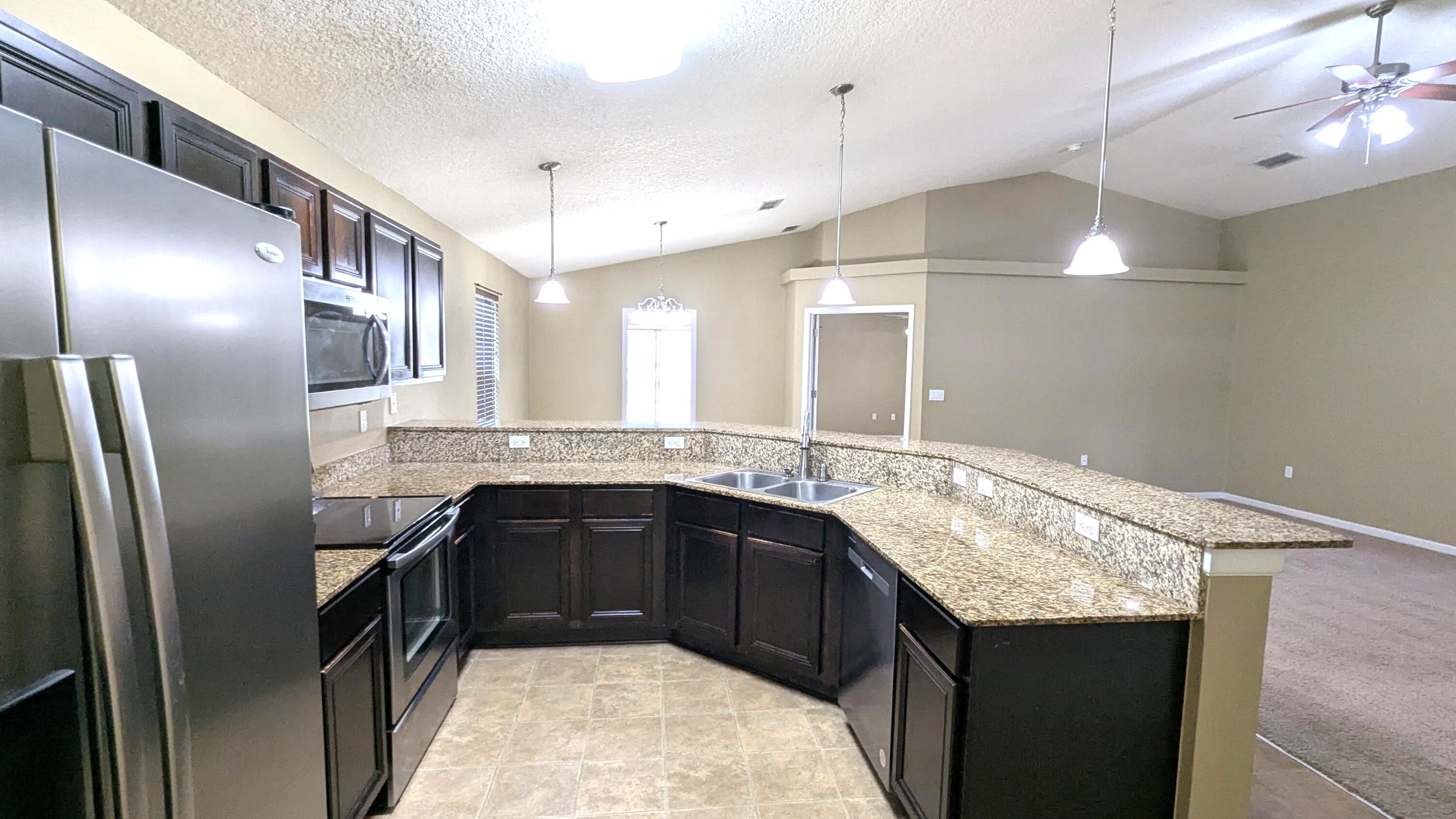 7976 Promise Creek Road Navarre, FL 32566 - Photo 10 of 29 a kitchen with a sink and refrigerator