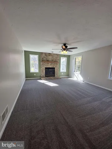 a view of an empty room with a fireplace and a window