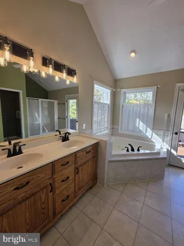 a spacious bathroom with a large tub sink and mirror