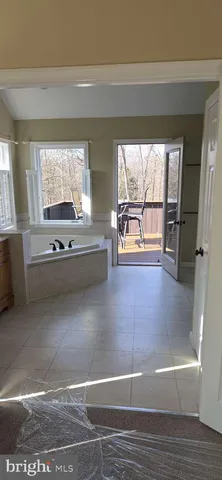 a view of a living room with furniture and large windows