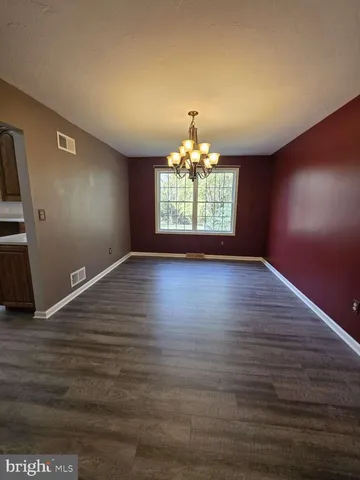 a view of room with wooden floor and chandelier