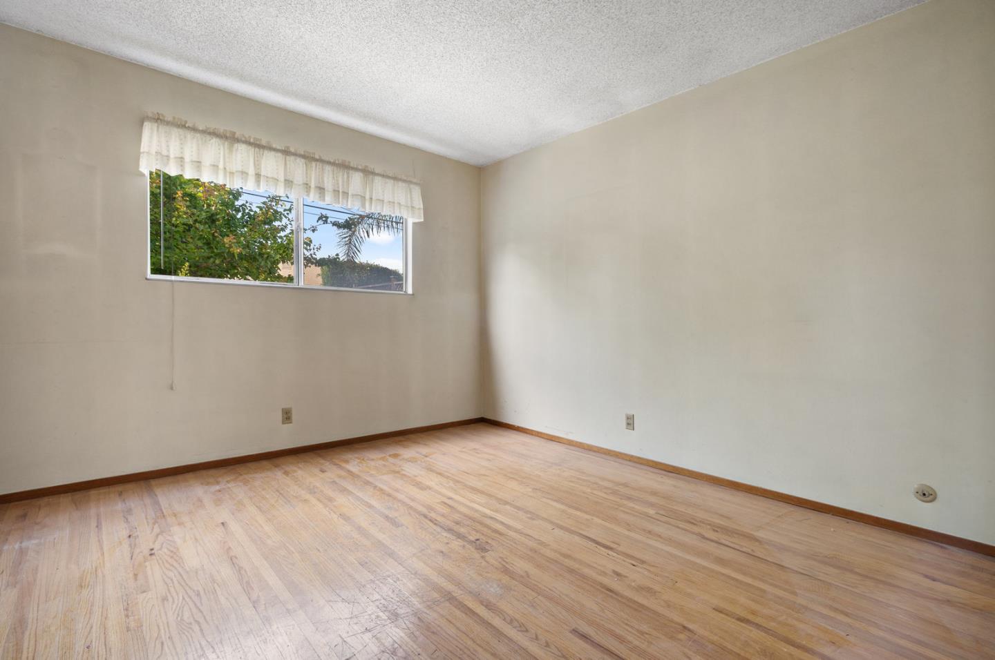 503 Paiute Lane San Jose, CA 95123 - Photo 7 of 18 an empty room with wooden floor and windows