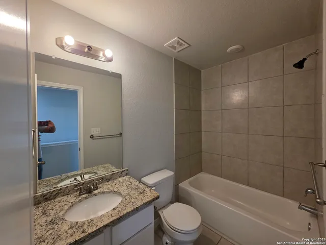 a bathroom with a granite countertop sink and shower