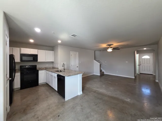 a kitchen with stainless steel appliances kitchen island granite countertop a refrigerator and a stove top oven