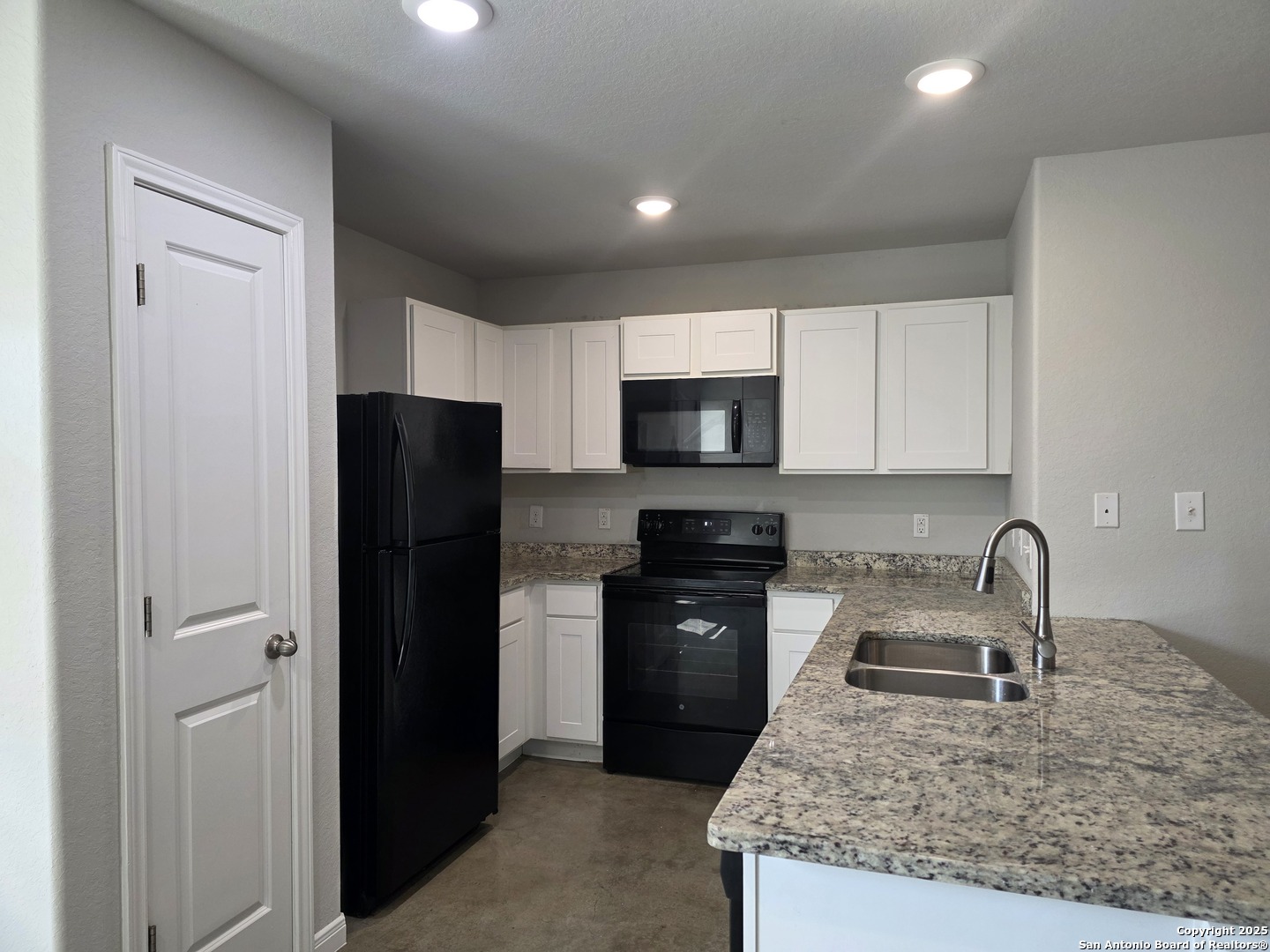 8410 Flicka Hills, Unit 2 Selma, TX 78154 - Photo 4 of 19 a kitchen with a sink a refrigerator and cabinets