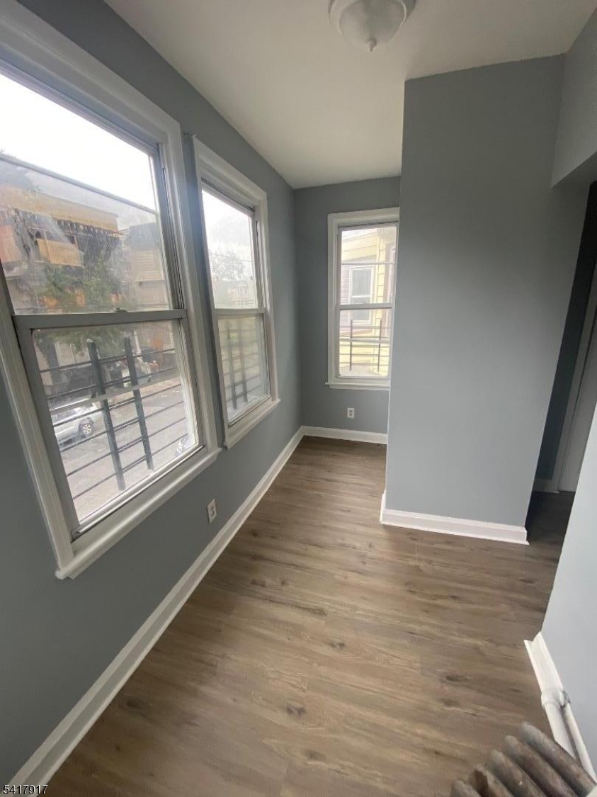 818 South 18th Street, Unit 2 Newark, NJ 07108 - Photo 4 of 12 a view of an empty room with wooden floor and a window