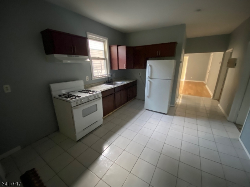 818 South 18th Street, Unit 2 Newark, NJ 07108 - Photo 6 of 12 a kitchen with a stove a refrigerator and a microwave