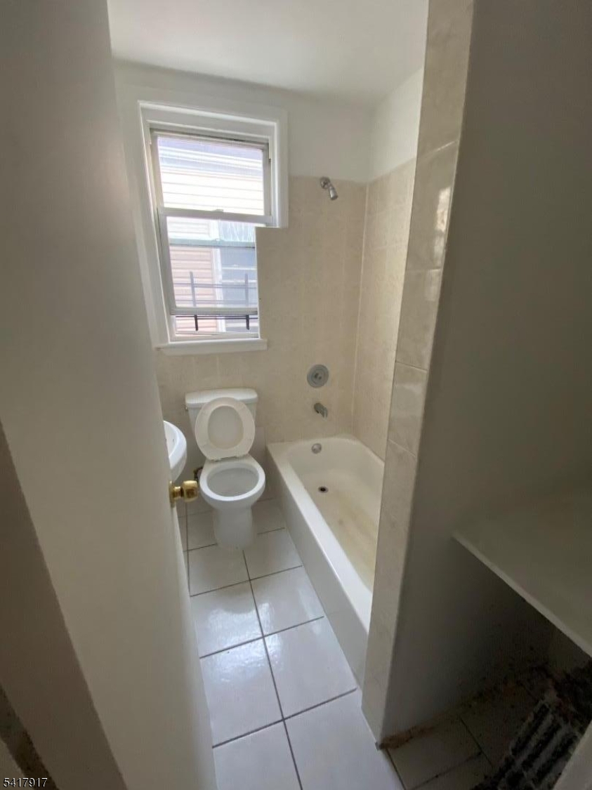 818 South 18th Street, Unit 2 Newark, NJ 07108 - Photo 8 of 12 a bathroom with a granite countertop bathtub a toilet and a shower