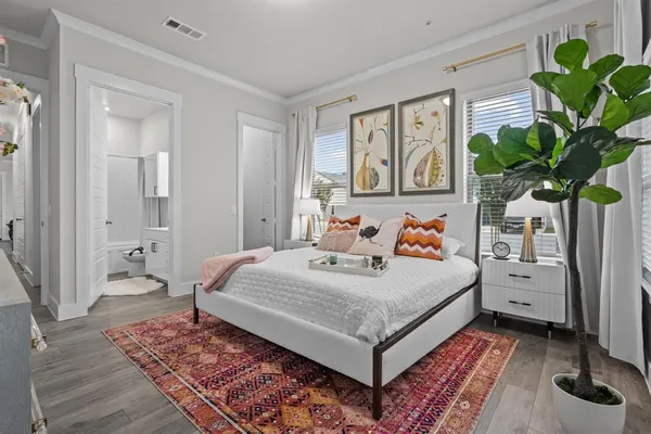 a bedroom with a bed dresser and window