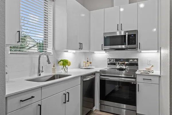 a kitchen with stainless steel appliances granite countertop a sink a stove and a granite counter tops