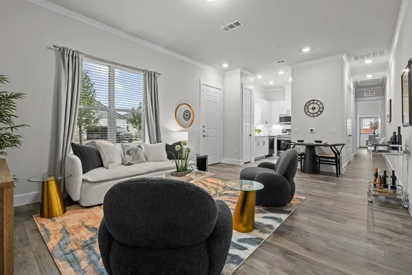 a living room with furniture a large window and wooden floor
