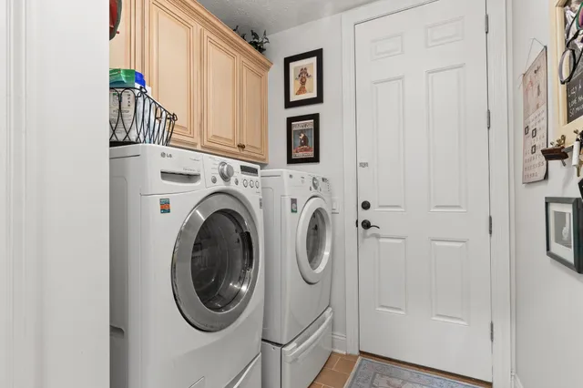 an aerial view of a house with a yard and trees all around