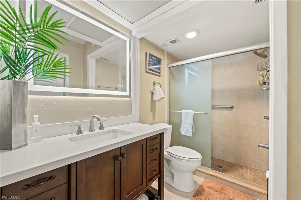 4021 Ice Castle Way, Unit 3407 Naples, FL 34112 - Photo 7 of 27 a bathroom with a granite countertop sink a toilet a mirror and shower