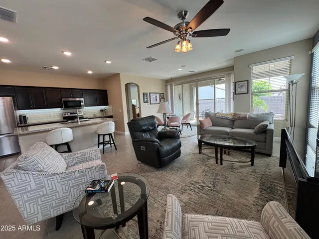 a living room with furniture a flat screen tv and kitchen view