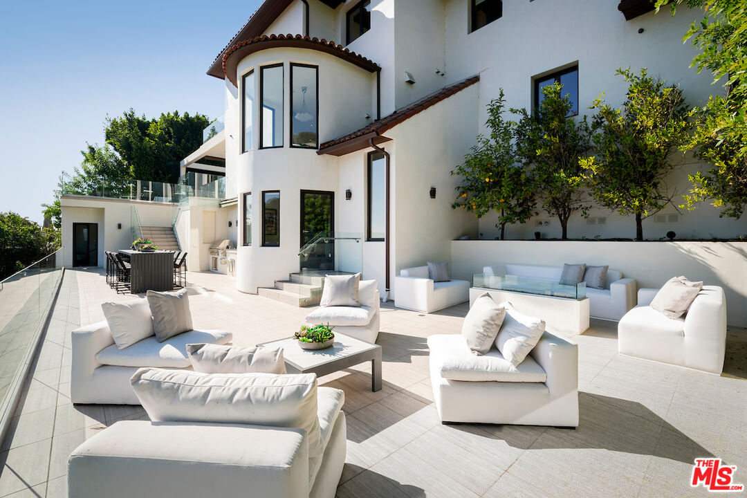 1280 Angelo Drive Beverly Hills, CA 90210 - Photo 53 of 66 a view of a patio with couches table and chairs with potted plants