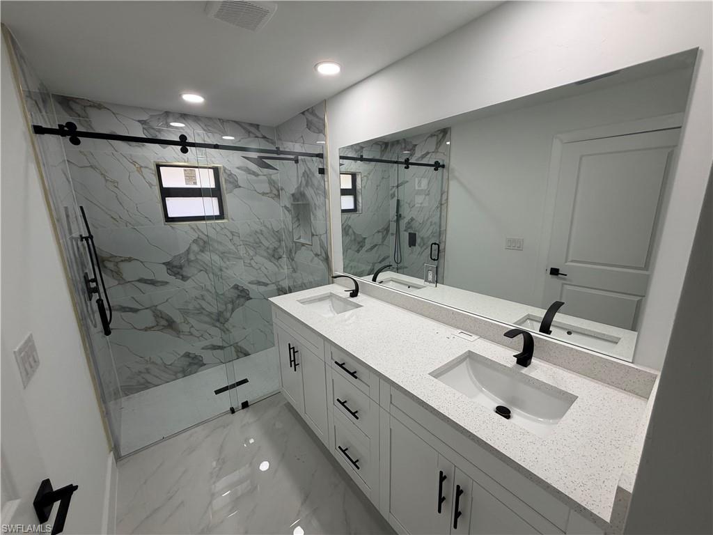 15 Louisiana Road Lehigh Acres, FL 33936 - Photo 2 of 22 a bathroom with a sink a mirror and shower
