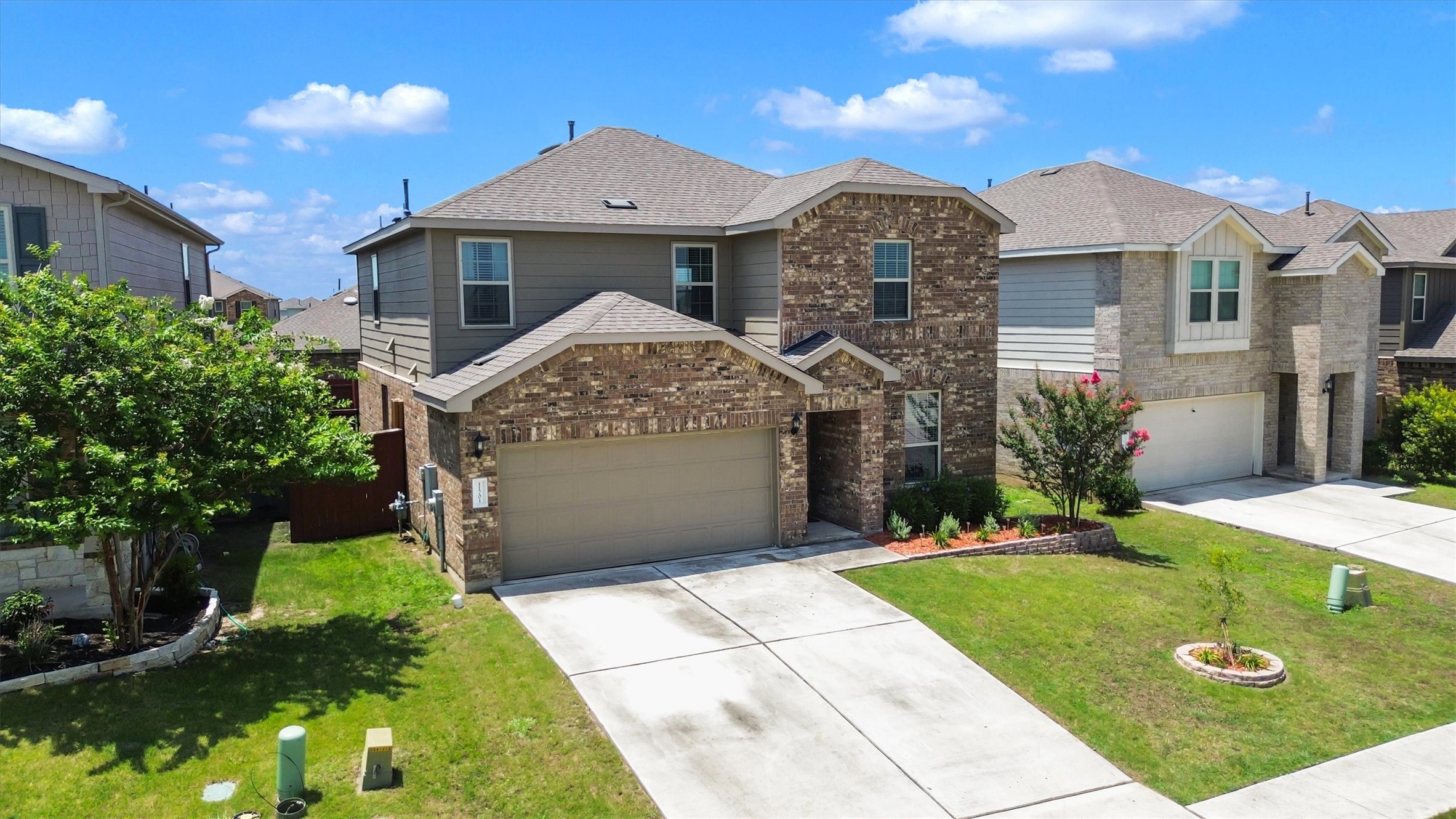 11701 Jackson Falls Way Manor, TX 78653 - Photo 35 of 40 A classic brick and siding two-story home, with an attached garage and well-maintained front yard.
