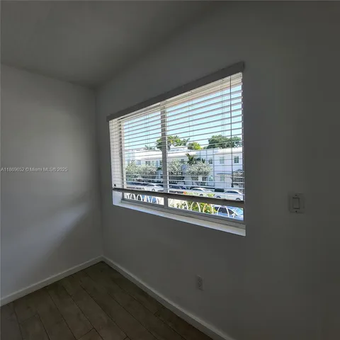 an empty room with wooden floor and a window