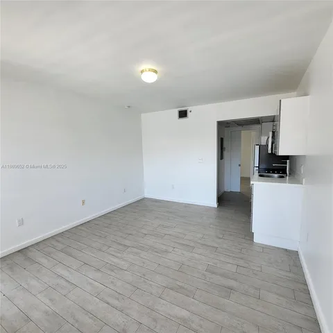 a view of a kitchen with a sink and a refrigerator