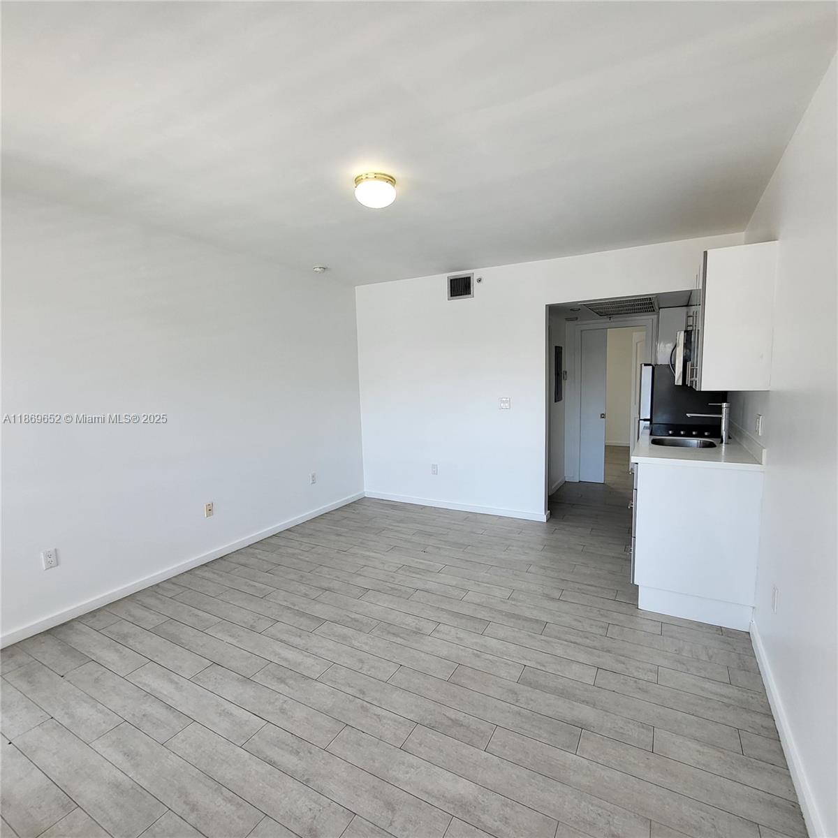 1601 Meridian Avenue, Unit 209 Miami Beach, FL 33139 - Photo 12 of 20 a view of a kitchen with a sink and a refrigerator