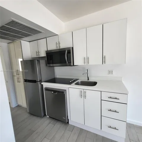 a kitchen with stainless steel appliances a sink cabinets and a refrigerator