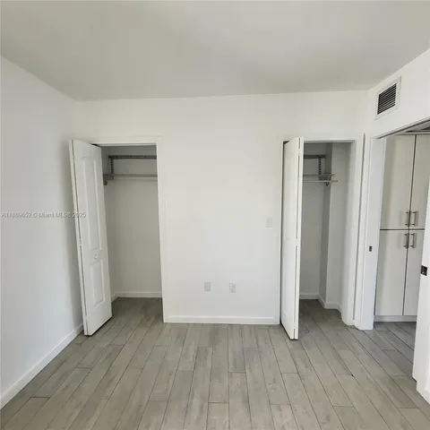 an empty room with wooden floor and closet