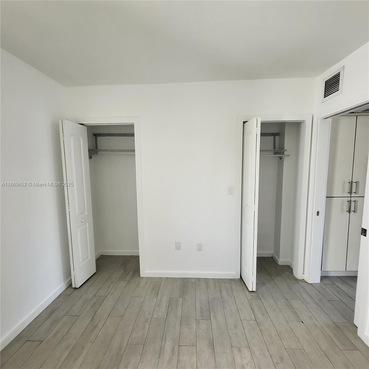 1601 Meridian Avenue, Unit 209 Miami Beach, FL 33139 - Photo 10 of 20 an empty room with wooden floor and closet